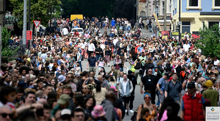 A large crowd moves down a street in St Pauls as part of St Pauls Carnival.